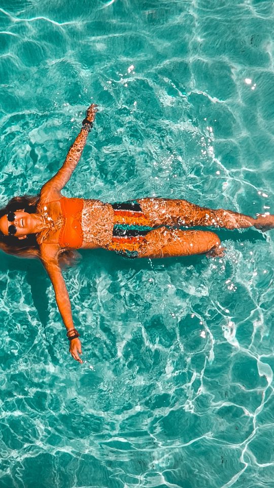 woman swimming alone in body of water